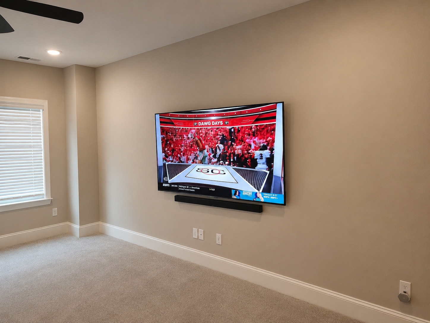 Large TV mounted on a great-room wall above a soundbar