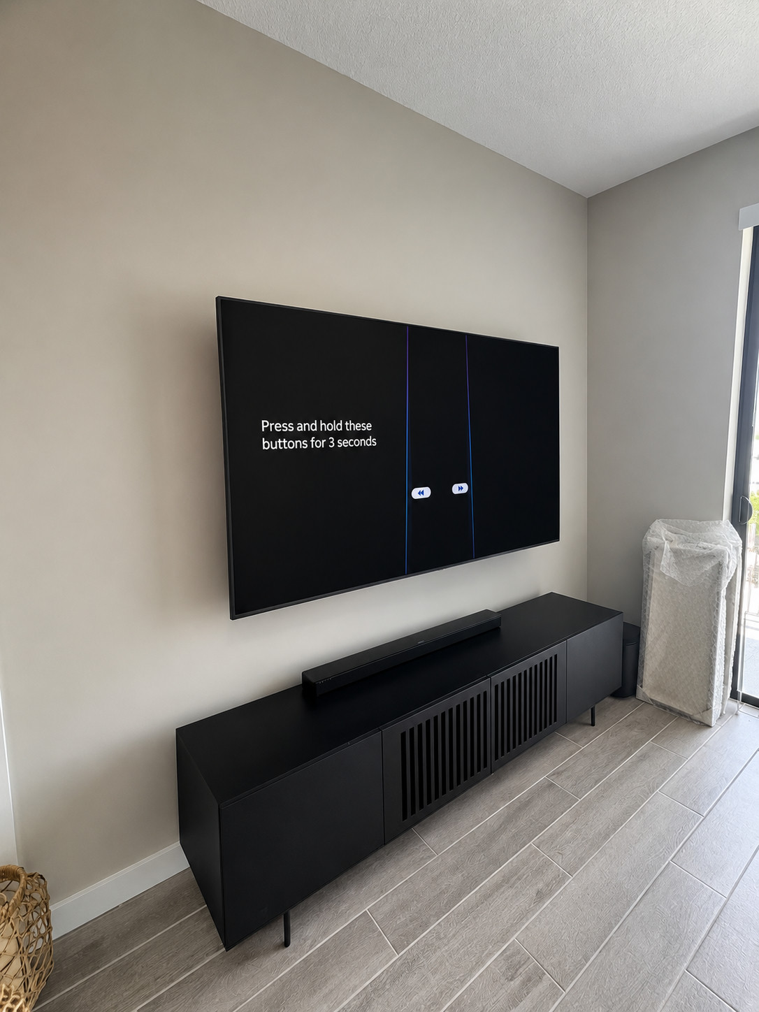 Flat TV flush-mounted over a black media console